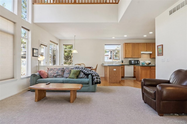 living area with baseboards, visible vents, and recessed lighting