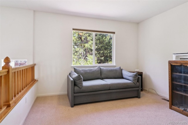 living area with light carpet and baseboards