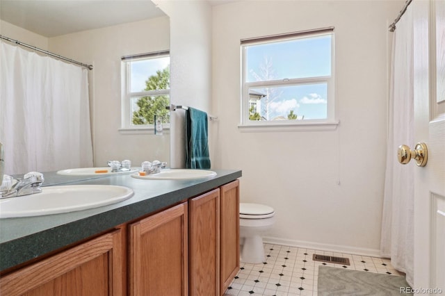 full bath featuring visible vents, a sink, toilet, and double vanity