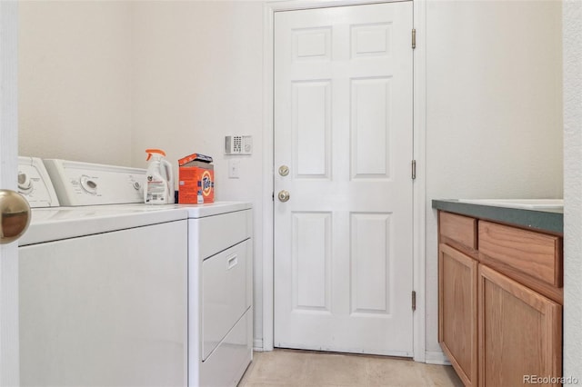 washroom with cabinet space, light tile patterned floors, and washer and dryer