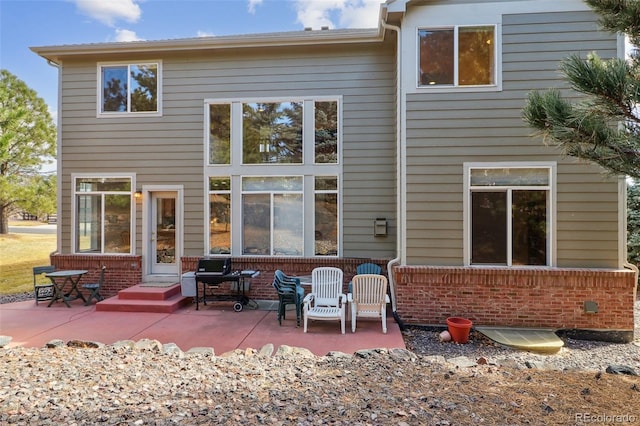 back of property with a patio area and brick siding