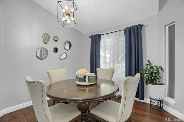 dining area featuring dark hardwood / wood-style flooring, a chandelier, and vaulted ceiling