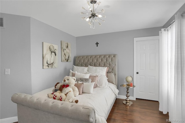 bedroom featuring dark hardwood / wood-style flooring and a chandelier