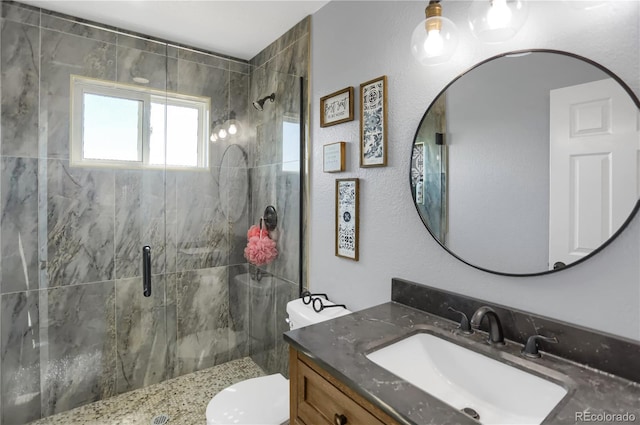 bathroom featuring toilet, an enclosed shower, and vanity