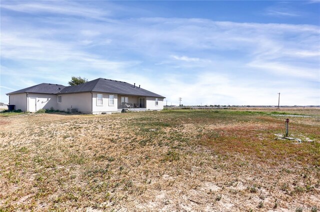 view of yard with a rural view and central AC