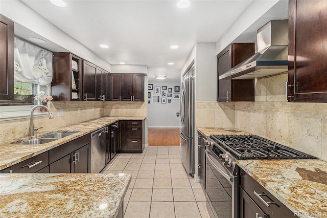 6731 Devinney St, Arvada, CO 80004 - kitchen with appliances with stainless steel finishes, a sink, wall chimney exhaust hood, dark brown cabinets, and light stone countertops