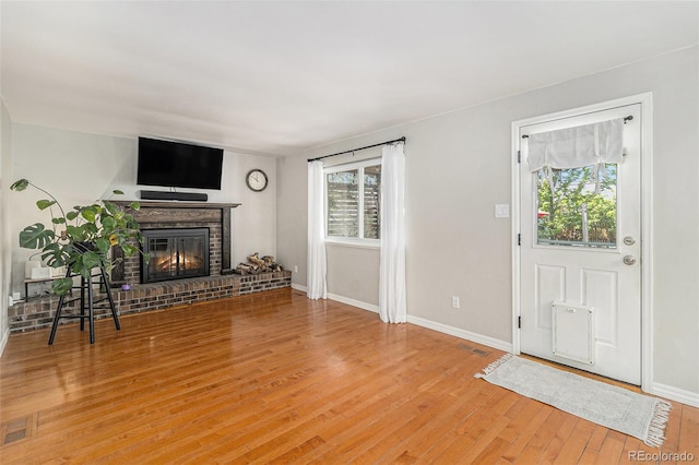 6731 Devinney St, Arvada, CO 80004 - unfurnished living room with a fireplace, light wood-style flooring, and baseboards