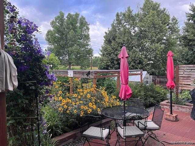 6731 Devinney St, Arvada, CO 80004 - view of patio with fence, outdoor dining space, and an exterior structure