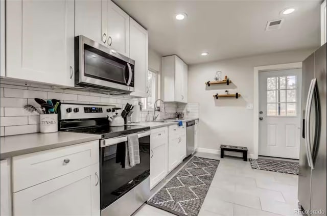 150 S Osceola St, Denver, CO 80219 - kitchen featuring stainless steel appliances, tasteful backsplash, white cabinets, light countertops, and recessed lighting