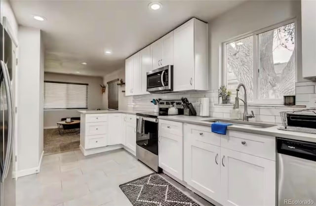 150 S Osceola St, Denver, CO 80219 - kitchen featuring appliances with stainless steel finishes, tasteful backsplash, white cabinets, recessed lighting, and light countertops