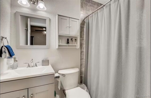 150 S Osceola St, Denver, CO 80219 - full bathroom with vanity, curtained shower, and a textured wall
