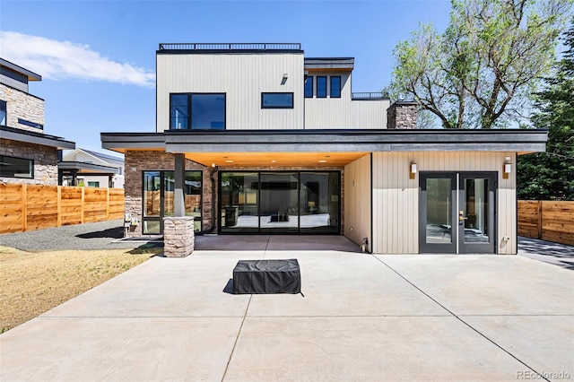 back of house with a patio area, french doors, fence, and a chimney