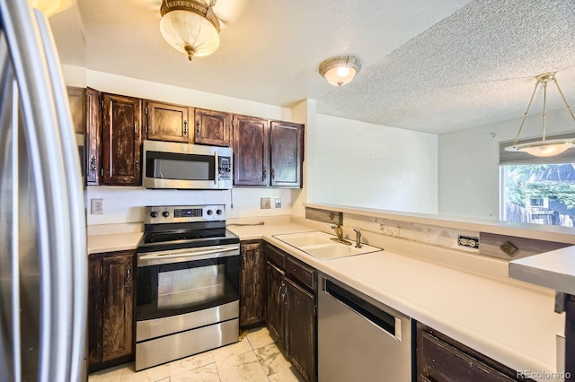 2370 Redwood Ave, Lafayette, CO 80026 - kitchen featuring stainless steel appliances, light marble finish flooring, dark brown cabinetry, light countertops, and pendant lighting