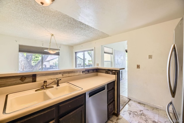 2370 Redwood Ave, Lafayette, CO 80026 - kitchen featuring stainless steel appliances, light marble finish floors, a textured ceiling, light countertops, and dark brown cabinetry