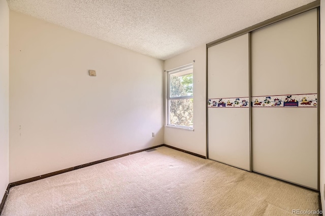 2370 Redwood Ave, Lafayette, CO 80026 - unfurnished bedroom featuring light colored carpet, a textured ceiling, and a closet