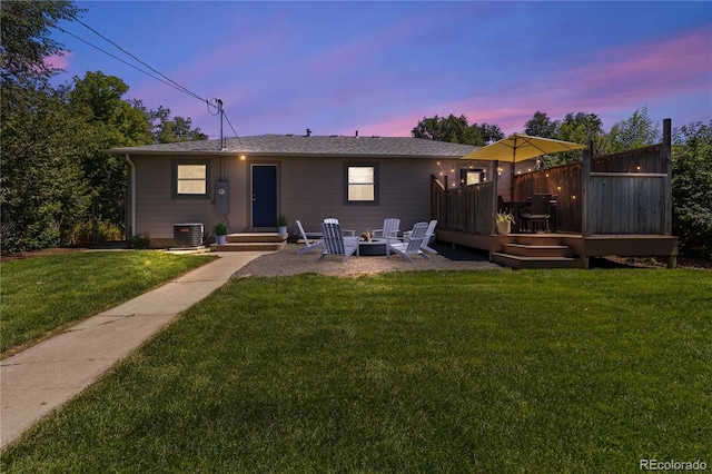 exterior space with central AC, a yard, a deck, and an outdoor fire pit