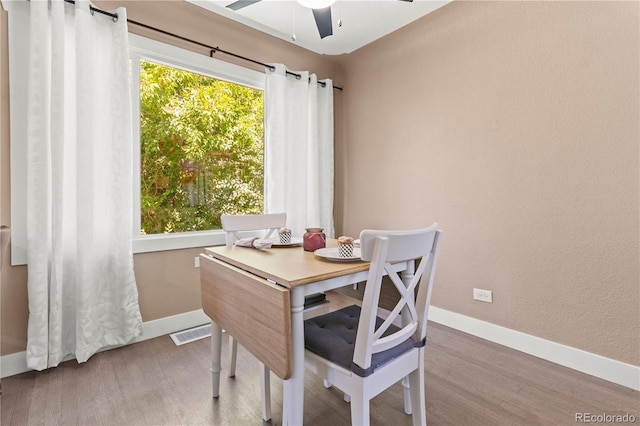 dining space with ceiling fan and hardwood / wood-style floors