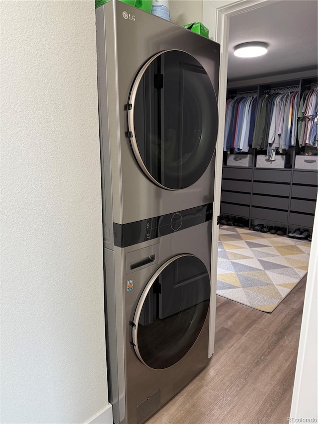 1694 Xanthia St, Denver, CO 80220 - washroom featuring stacked washing machine and dryer and wood finished floors