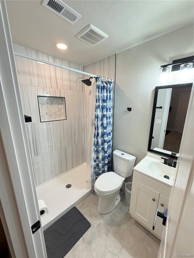 1694 Xanthia St, Denver, CO 80220 - bathroom featuring toilet, vanity, a stall shower, a textured ceiling, and a textured wall