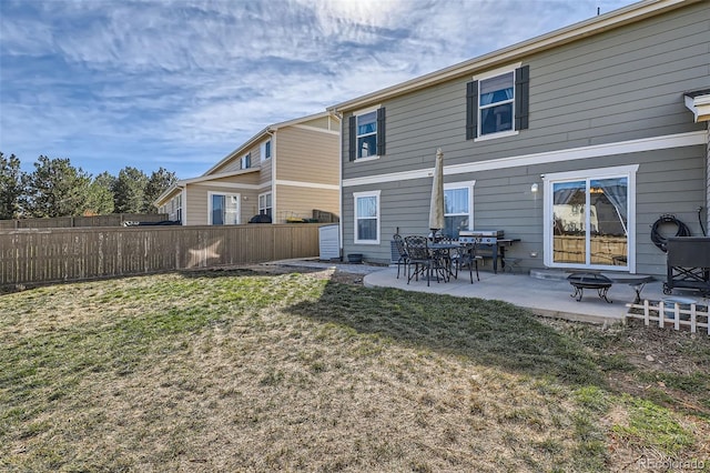 rear view of house with a lawn, an outdoor fire pit, and a patio