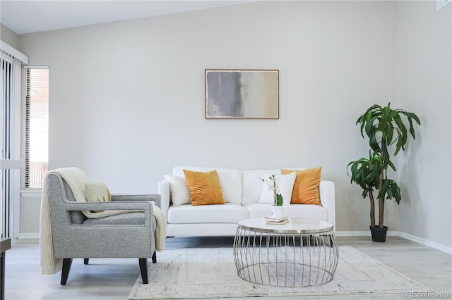 living area with baseboards and wood finished floors