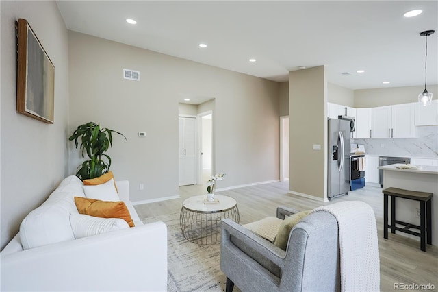 living room featuring visible vents, recessed lighting, baseboards, and light wood-style floors