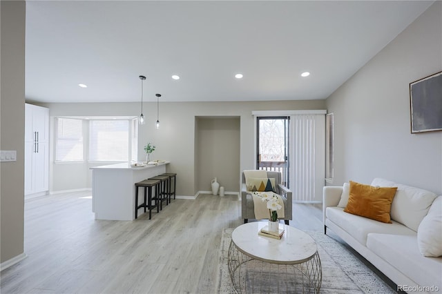 living room with light wood finished floors, recessed lighting, and baseboards