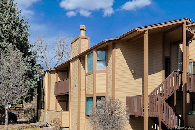 view of home's exterior featuring stairs and a chimney