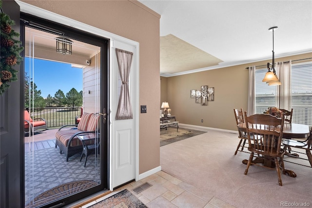 carpeted dining room with crown molding