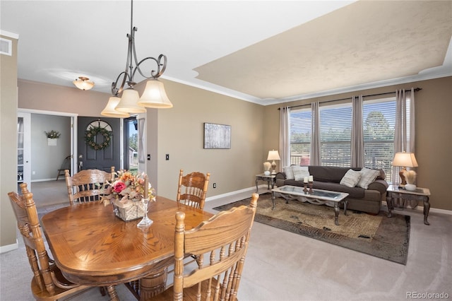 carpeted dining area with ornamental molding