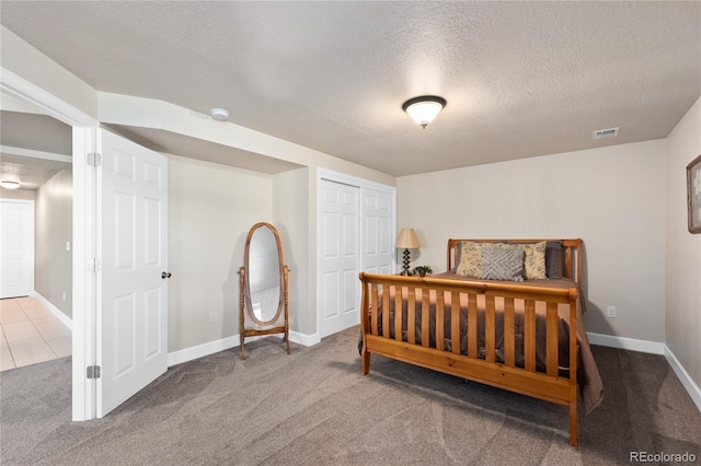 bedroom featuring a closet, carpet flooring, and a textured ceiling