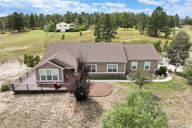 view of front facade featuring a wooden deck and a front yard