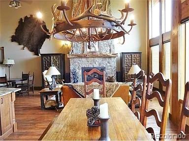 59 Club House Road 1/2Quarter Share D, Breckenridge, CO 80424 - dining area featuring a chandelier, wood finished floors, and a stone fireplace