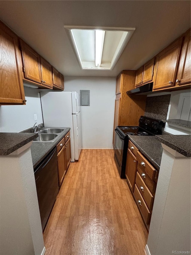 kitchen featuring sink, decorative backsplash, electric panel, black appliances, and light hardwood / wood-style flooring