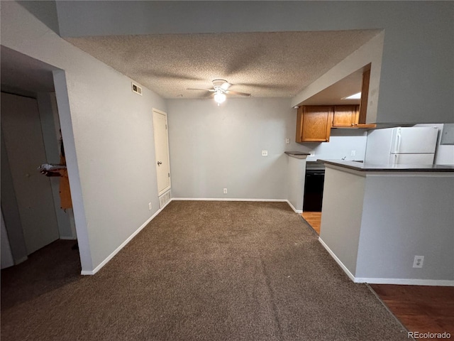 kitchen featuring ceiling fan, carpet floors, white fridge, and a textured ceiling