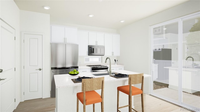 kitchen featuring sink, light hardwood / wood-style flooring, stainless steel appliances, a kitchen island with sink, and white cabinets