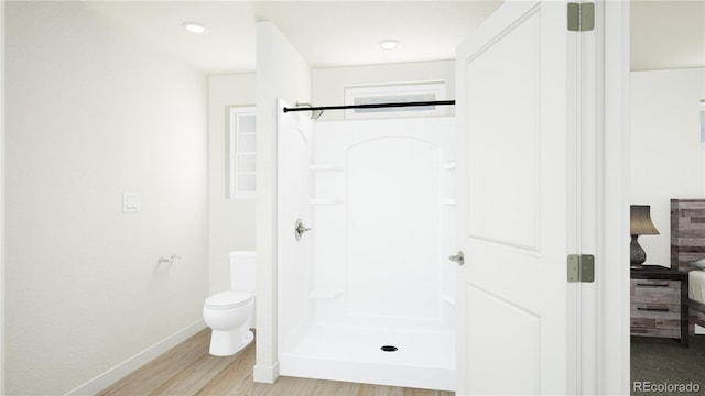 bathroom featuring hardwood / wood-style floors, toilet, and walk in shower