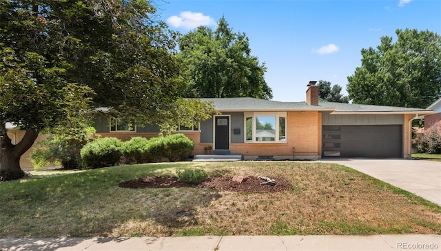 2963 S Vrain St, Denver, CO 80236 - view of front of property with an attached garage, driveway, a chimney, brick siding, and a front lawn