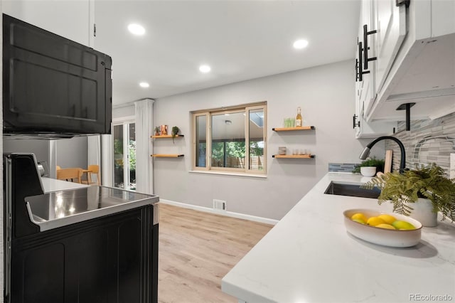 2963 S Vrain St, Denver, CO 80236 - kitchen with open shelves, backsplash, healthy amount of natural light, recessed lighting, and light wood-style floors