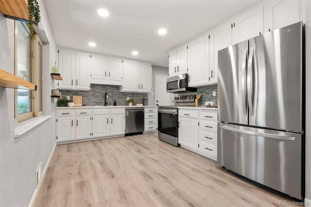 2963 S Vrain St, Denver, CO 80236 - kitchen featuring stainless steel appliances, light countertops, backsplash, white cabinetry, and recessed lighting
