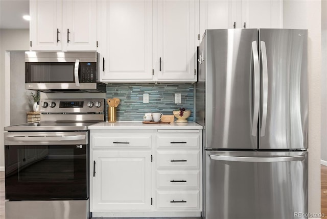 2963 S Vrain St, Denver, CO 80236 - kitchen featuring stainless steel appliances, decorative backsplash, white cabinetry, and light countertops