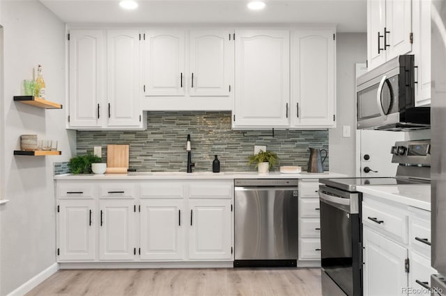 2963 S Vrain St, Denver, CO 80236 - kitchen featuring appliances with stainless steel finishes, open shelves, light wood-style floors, light countertops, and recessed lighting