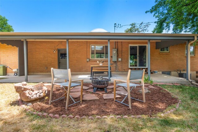 2963 S Vrain St, Denver, CO 80236 - rear view of property with an outdoor fire pit, a patio, and brick siding