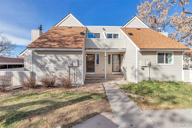 view of front of home featuring a balcony and a front yard