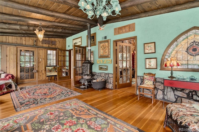 5975 Wellington Rd, Cascade, CO 80809 - living area featuring wood-type flooring, a chandelier, wood ceiling, and wooden walls