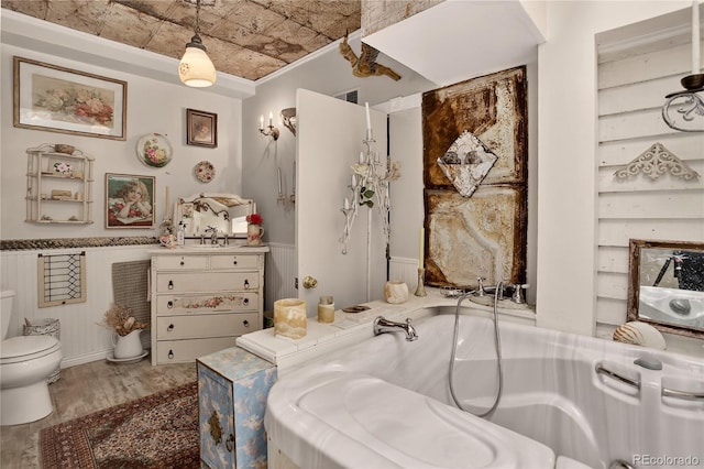 5975 Wellington Rd, Cascade, CO 80809 - bathroom featuring a bath, wood finished floors, wainscoting, an ornate ceiling, and crown molding