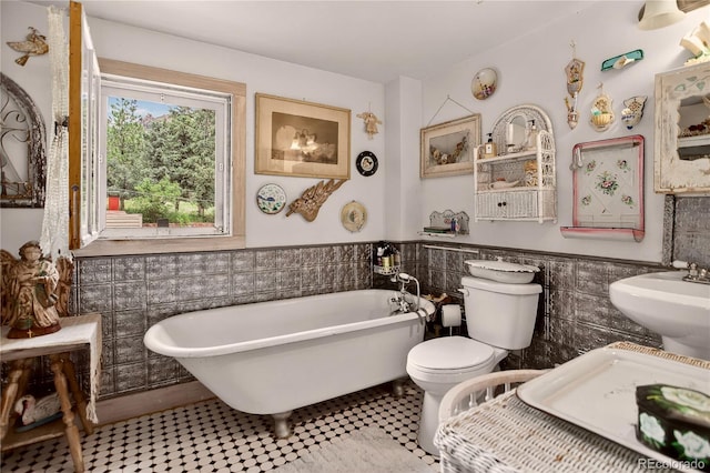 5975 Wellington Rd, Cascade, CO 80809 - bathroom featuring tile walls, a freestanding bath, wainscoting, and a bidet