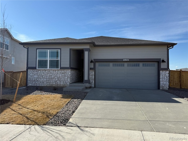 view of front facade with stone siding, concrete driveway, fence, and an attached garage