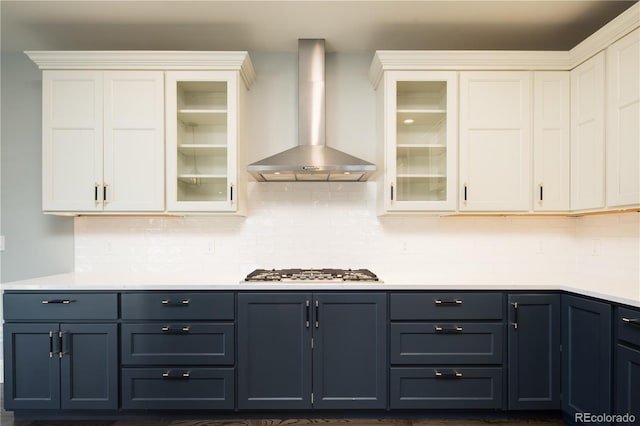 kitchen featuring white cabinets, stainless steel gas stovetop, wall chimney exhaust hood, and tasteful backsplash