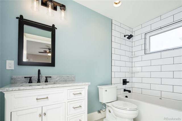 full bathroom with toilet, ceiling fan, tiled shower / bath, and vanity